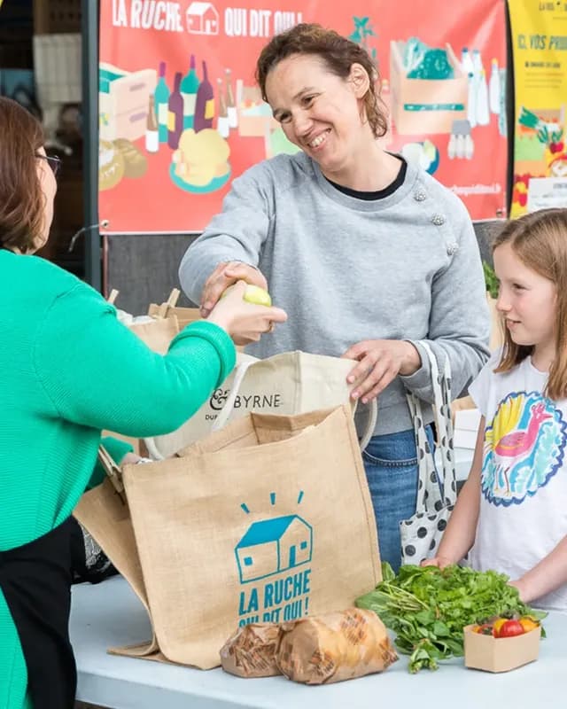 Remise d’un sac de courses dans un point de collecte